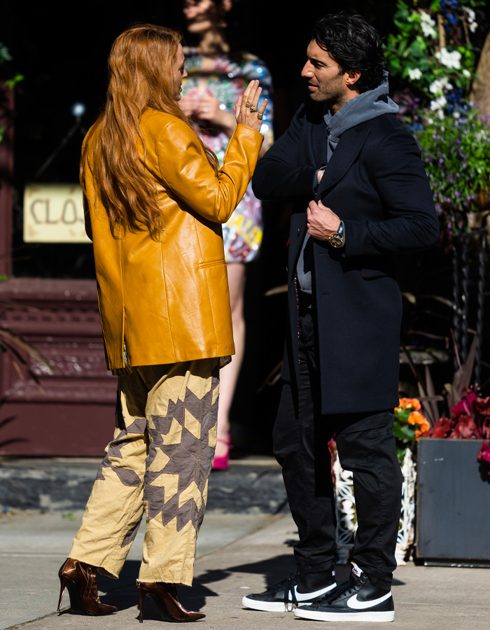 Two people engaged in conversation outdoors, highlighting Blake Lively's scathing lawsuit statement causing fan frenzy.