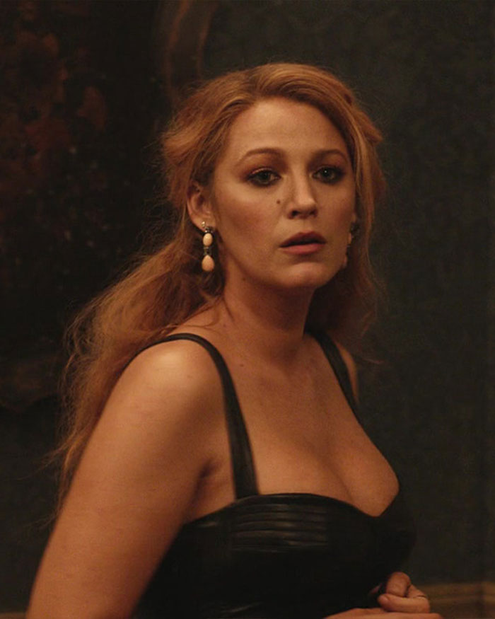 Blake Lively em um vestido preto e brincos, parecendo preocupada durante sua violenta batalha legal com Justin Baldoni.
