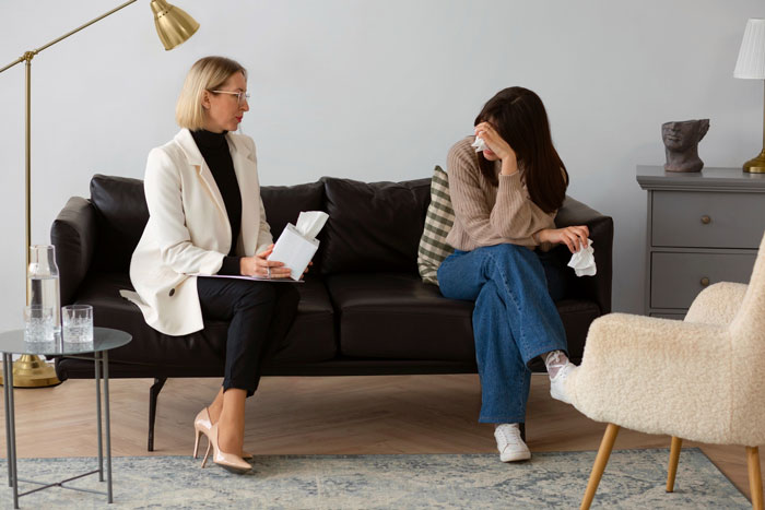 Woman acting as a book store manager comforting a distressed young woman upset by a school bully in a therapy-like setting. Woman acting as a book store manager comforting a distressed young woman upset by a school bully in a therapy-like setting.