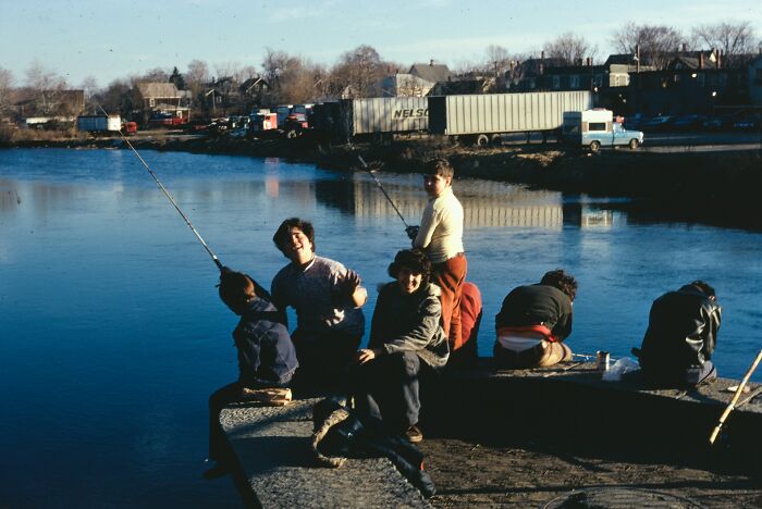 Children fishing by a river on a dock, illustrating childhood moments that show kids have no survival instincts.