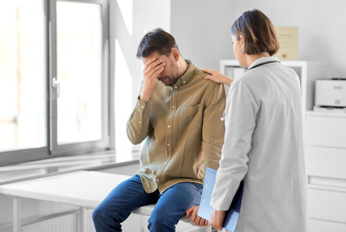 A man covers his face in distress, comforted by a doctor, relating to the change from "Dad" to "Uncle". A man covers his face in distress, comforted by a doctor, relating to the change from "Dad" to "Uncle".