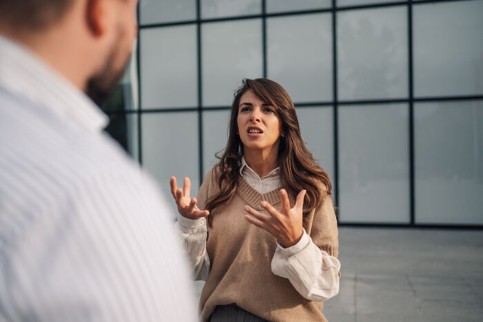 A woman, visibly upset, gestures while talking to someone off-camera, discussing stories of being cheated on.