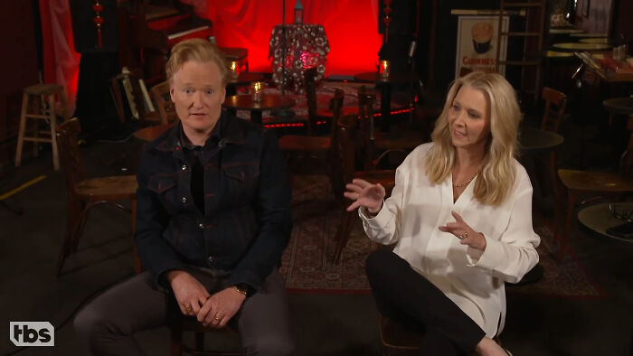 Two people sitting indoors engaged in conversation depicting celebrity friendships