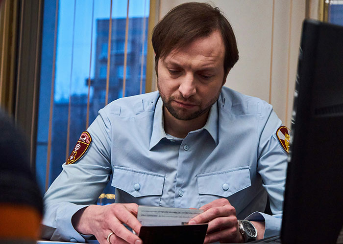 Police officer in uniform examining documents indoors, illustrating funny and wild stories about police chasing the wrong person.