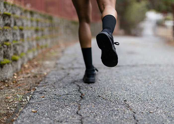 Person running on a cracked pavement, illustrating a police chase scene related to chasing the wrong person concept.