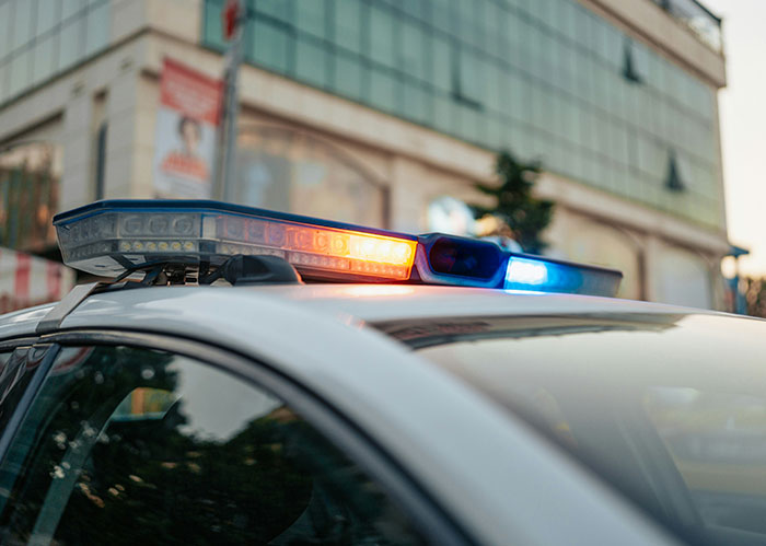 Police car lights flashing during a wild police chase incident involving the wrong person in an urban setting.