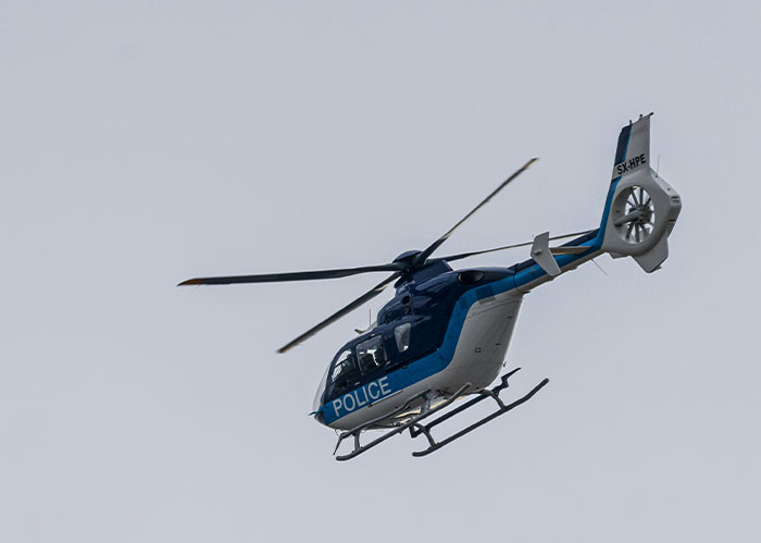 Police helicopter in flight during a wild police chase, searching for the wrong person in a dramatic law enforcement scene.
