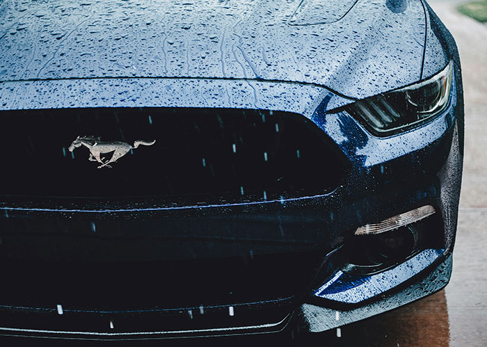 Close-up of a blue car grille with raindrops, illustrating a funny and wild police chasing the wrong person story.