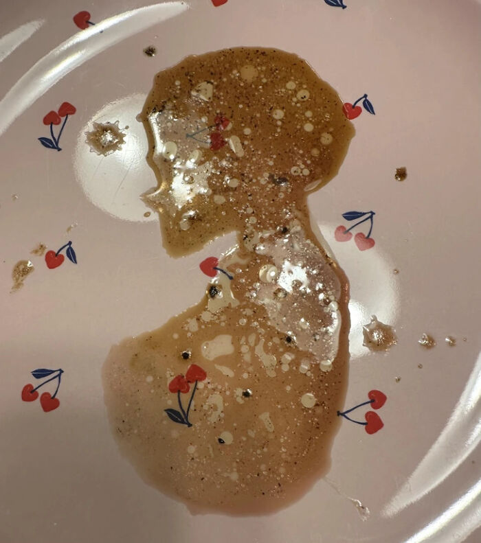 Coffee spill forming a human silhouette on cherry pattern plate
