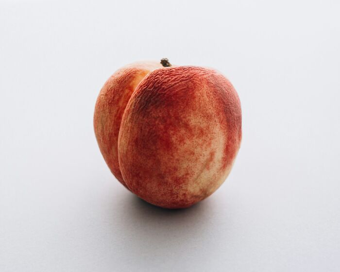 Close-up of a ripe peach on a white surface, symbolizing gynecologists reflecting on challenging appointments.