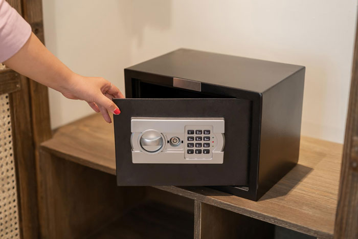 Person opening a black digital safe with keypad, symbolizing secrets exposed by a woman leading to a criminal&rsquo;s jail time.