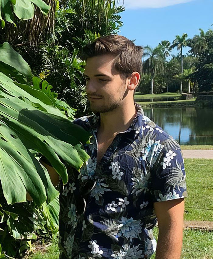 Handsome New York Botanical Garden scientist examining large green leaves outdoors by a pond on a sunny day. Handsome New York Botanical Garden scientist examining large green leaves outdoors by a pond on a sunny day.