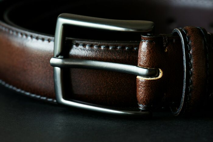 Close-up of a brown leather belt with a metal buckle, one of the items TSA has had to confiscate from passengers.