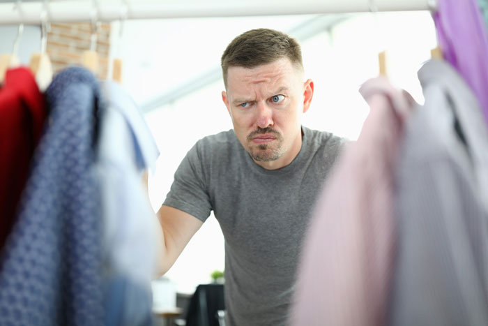 A disgusted dad looks through his clean underwear hanging on a clothesline, perhaps realizing his toilet seat fate.