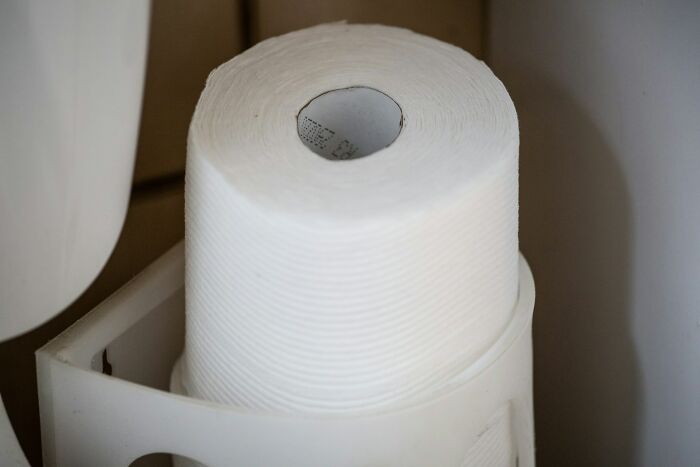 Roll of white paper towel in a dispenser, illustrating practical tips and tricks parents use in daily life.