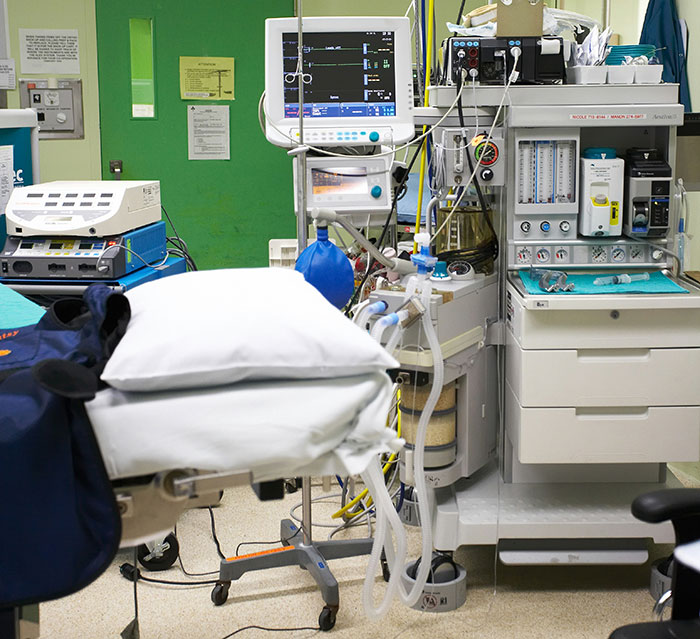 A hospital room with medical equipment, a patient bed, and monitors. Medical professionals use this equipment for patient care.