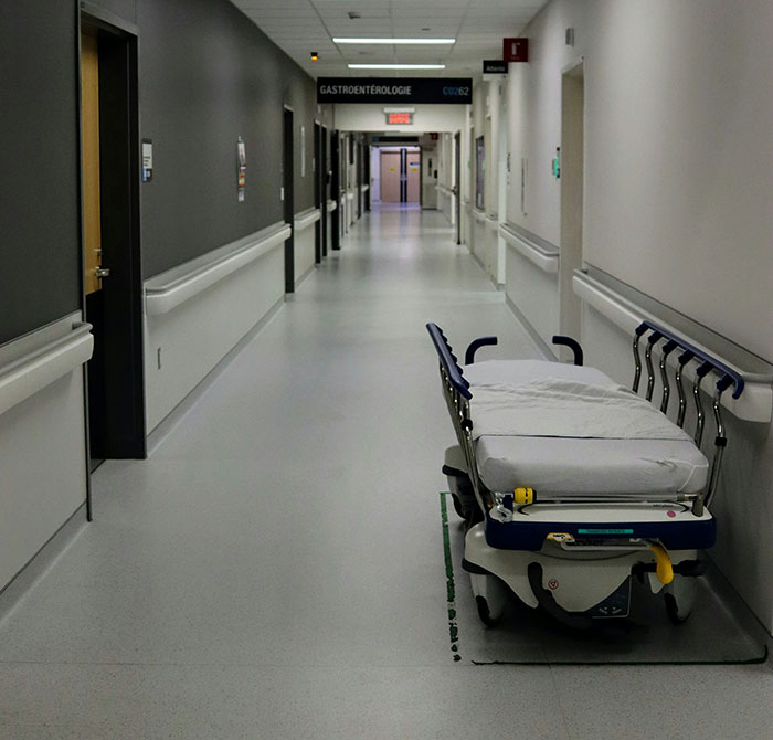 A long hospital corridor with a stretcher parked on the right, perfect for medical professionals sharing patient stories.