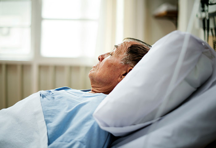 Elderly patient lying in a hospital bed, looking up. Medical professionals share patient stories that are not for the weak.