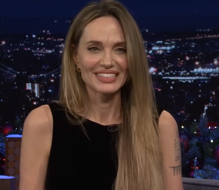 Female celebrity with long blonde hair smiling during a nighttime interview, representing disturbing celebrity facts.