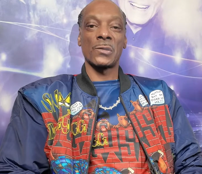 Snoop Dogg wearing a colorful jacket and necklace, featured in disturbing celebrity facts coverage.