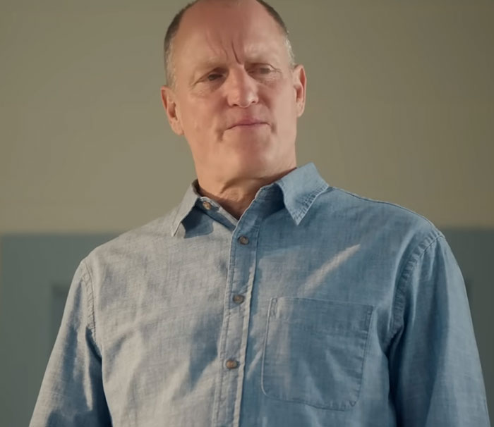 Middle-aged man in a denim shirt looking thoughtful, illustrating disturbing celebrity facts concept.