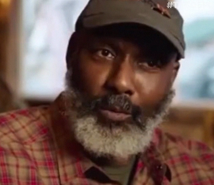 Close-up of a man with a gray beard and cap, discussing disturbing celebrity facts in a casual indoor setting.