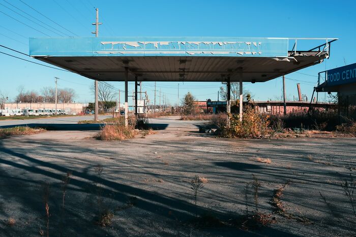Abandoned gas station and overgrown lot in one of the worst places in the US that people have ever visited.