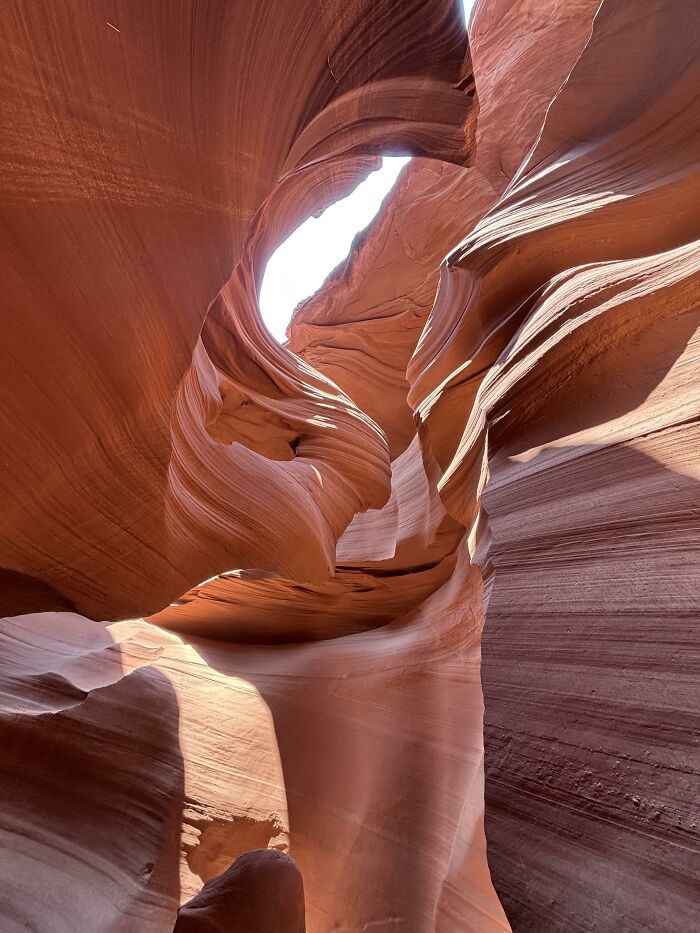 Captivating slot canyon with swirling orange and red rock formations. Sunlight streams from above, a satisfying picture for a gentle reset.