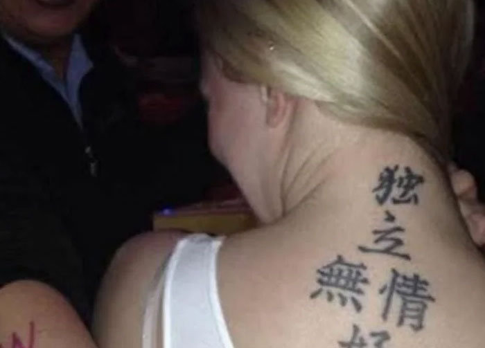 Woman with black Chinese or Japanese character tattoo on the back of her neck, highlighting amusing language tattoo errors.