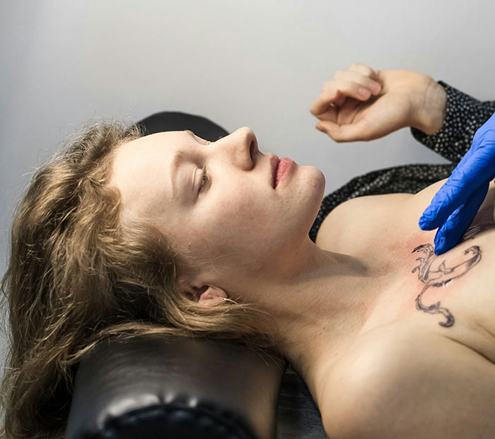 Person getting a chest tattoo with Chinese and Japanese characters, showcasing amusing tattoo translations by experts.