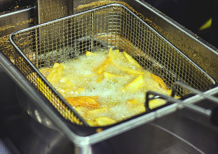 Deep fryer basket filled with potatoes frying in hot oil, illustrating coworkers who took stupidity to new heights.