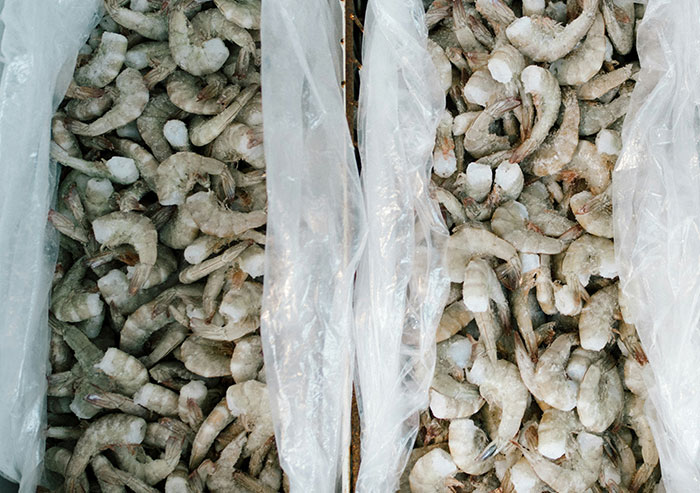 Frozen shrimp packed in plastic at a seafood market, illustrating coworkers who took stupidity to new heights.