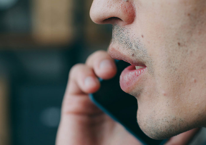 Close-up of a coworker speaking on the phone, highlighting everyday office moments of coworkers in a workplace setting.