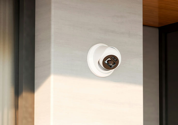 Security camera mounted on interior office wall capturing coworkers acting with unexpected stupidity in a workplace setting