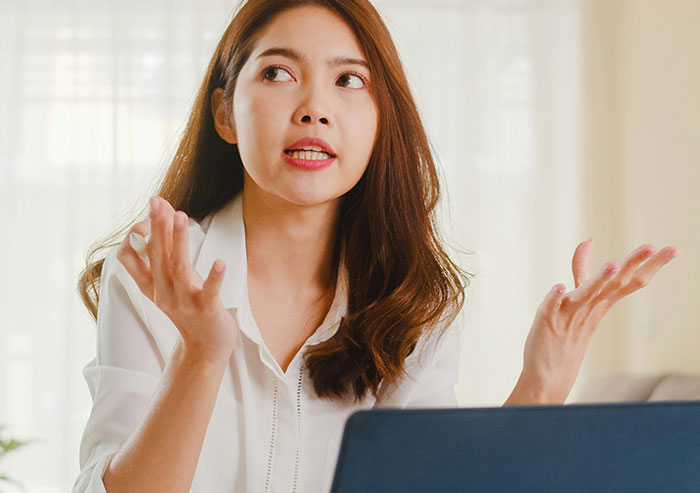 Young woman coworker expressing frustration during a work discussion, illustrating moments of coworker stupidity at the office.