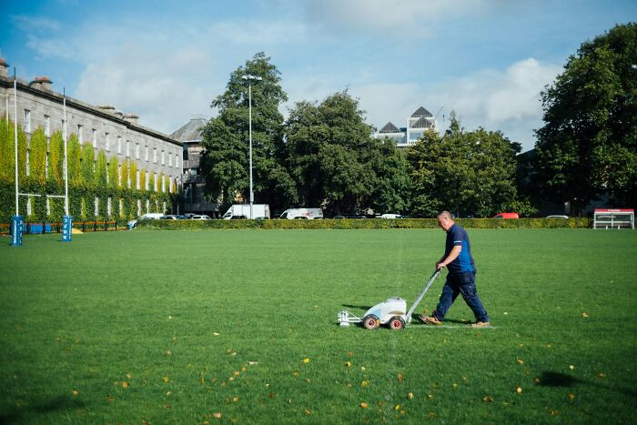 Man mowing a large green field, symbolizing the effort of being a good person leading to unexpected betrayal.