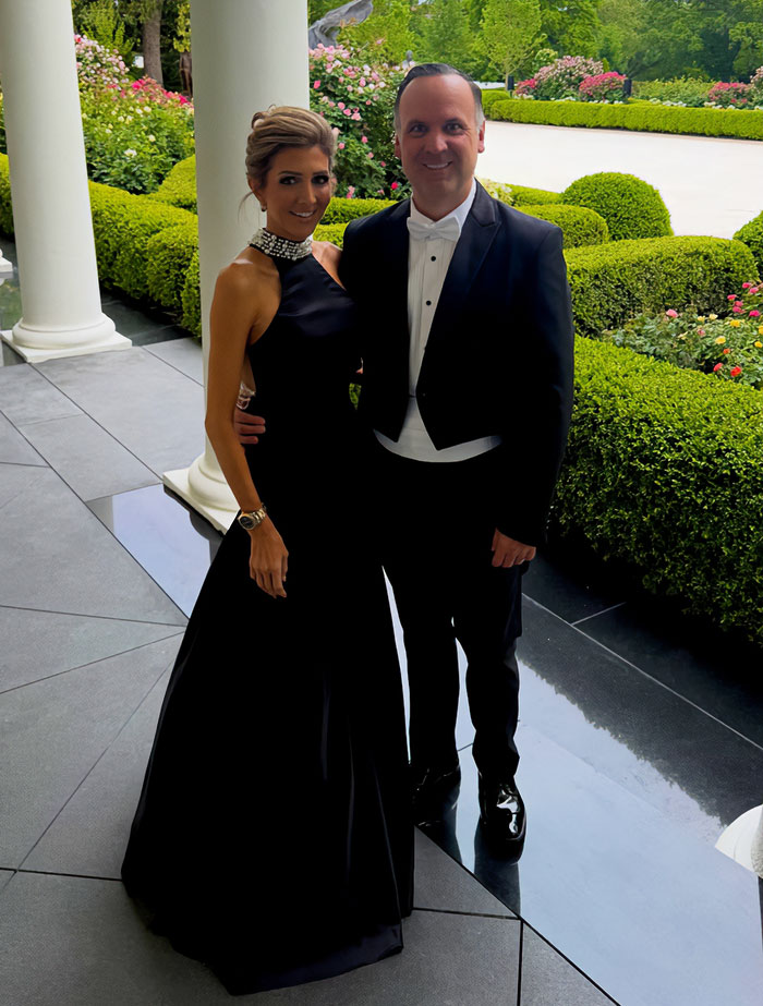 A couple in formal black attire at the White House, showcasing one of the looks from MAGA figures during the King Charles visit.