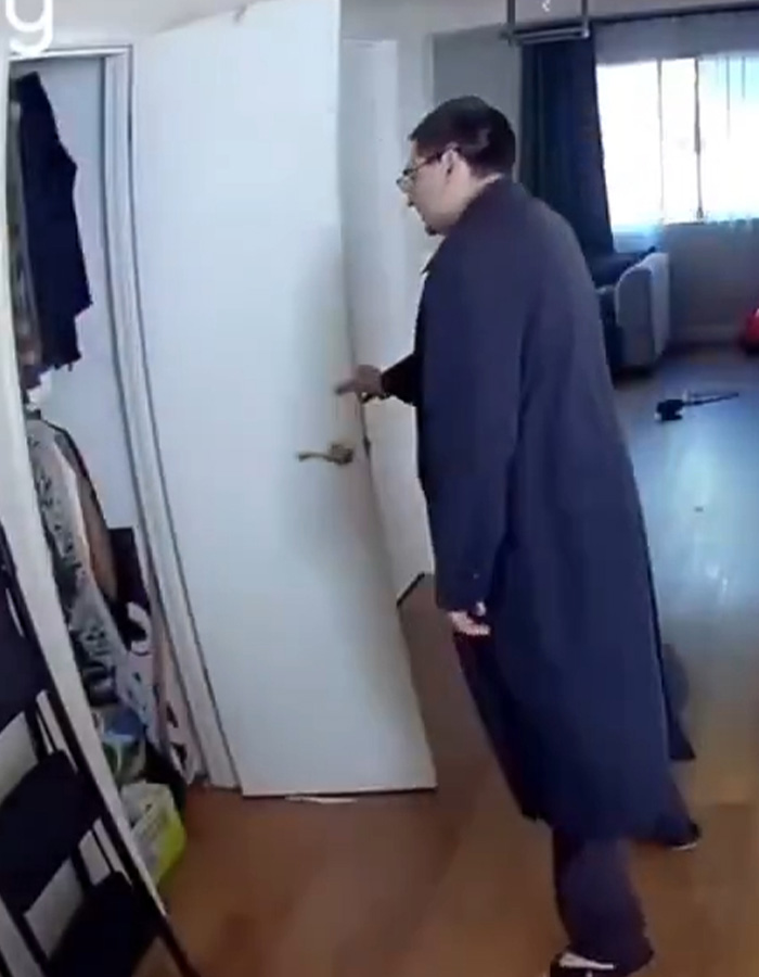 Homem vestido com casaco escuro abrindo a porta de uma casa capturada pela vigilância por vídeo de intrusos em Fairfield.