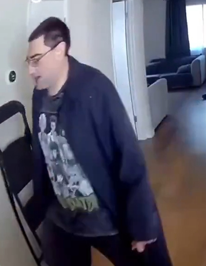 Homem dentro de uma casa usando óculos e roupas escuras, relacionado ao intruso de Fairfield visto no vídeo.