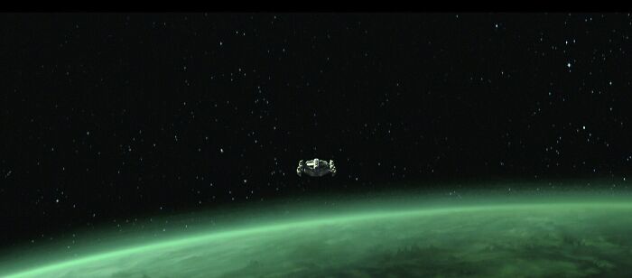 Spacecraft orbiting a green planet in a star-filled outer space setting from Star Wars Maul Shadow Lord series.