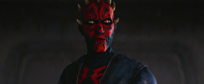 Star Wars Maul character in dark setting with red and black facial markings in a dramatic pose.