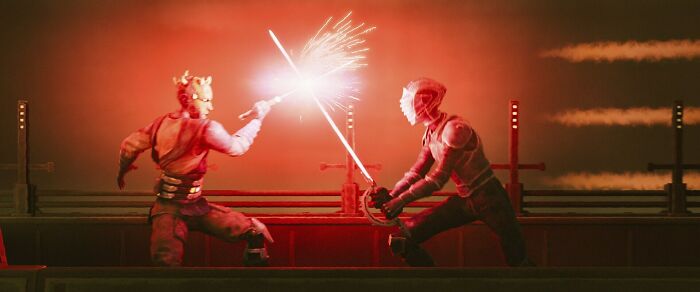 Star Wars Maul Shadow Lord lightsaber duel scene with two characters fighting in a dark red setting.