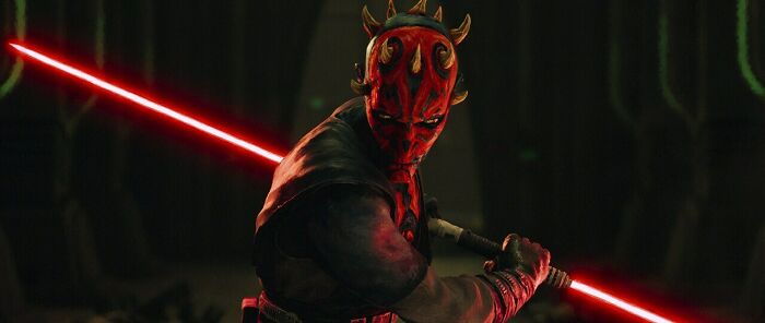 Darth Maul wielding a red double-bladed lightsaber in a dark setting for Star Wars Maul Shadow Lord release.