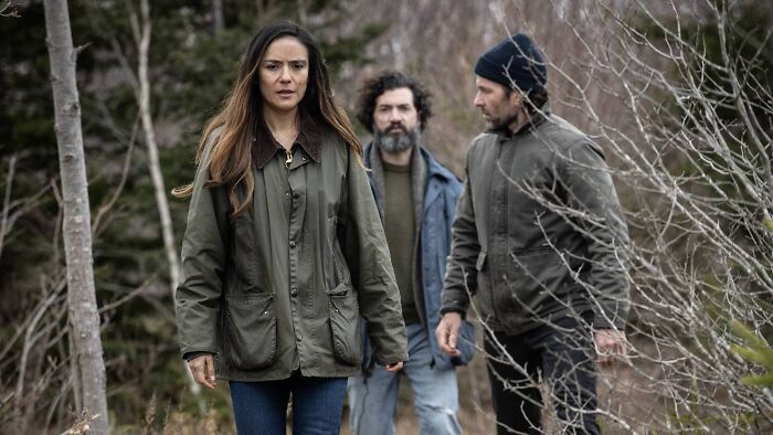 Três personagens da 4ª temporada caminhando por uma floresta, destacando uma reviravolta aterrorizante na estreia da série.