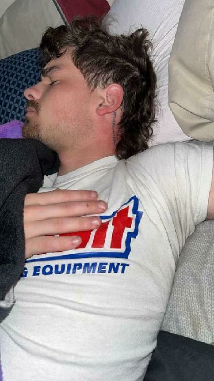 Young man sleeping sideways with hand on chest, showcasing one of the hilarious and unhinged ways people sleep.
