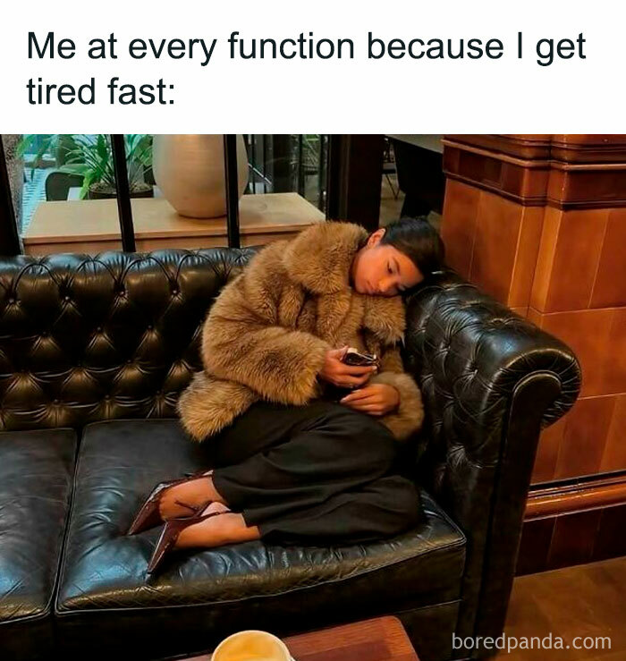 Person wearing a fur coat lying on a leather couch looking tired, illustrating meme scrolling for a daily chuckle.