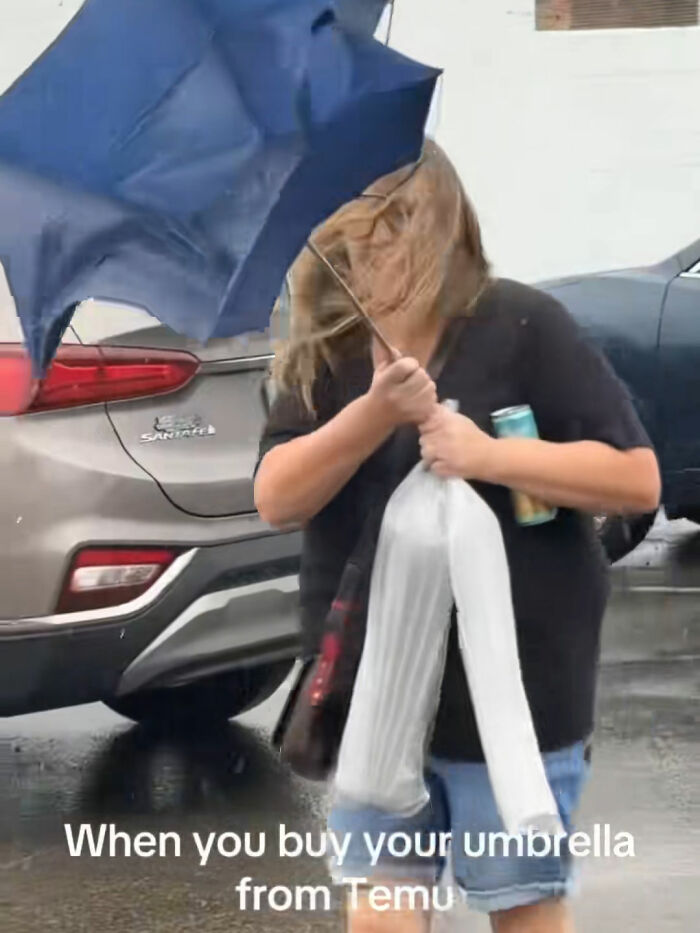 Woman struggling with a broken umbrella in the wind after ordering from Temu, showcasing a funny Temu lesson moment.