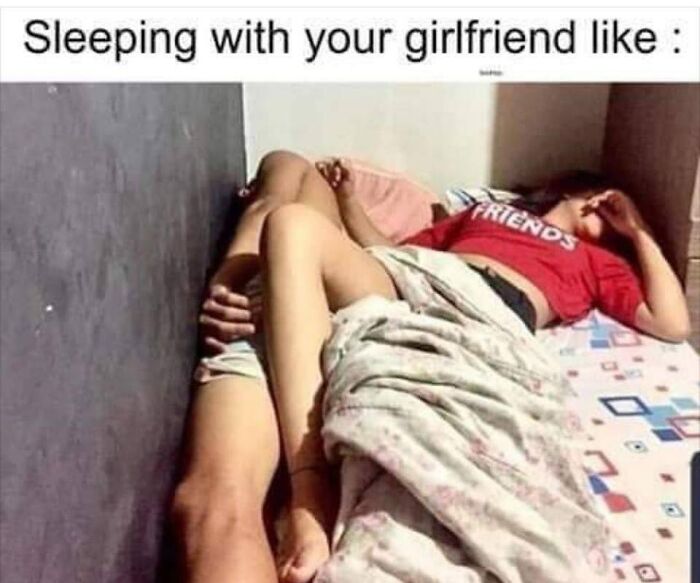 Couple lying in bed in a humorous pose illustrating relatable romantic relationships meme content.