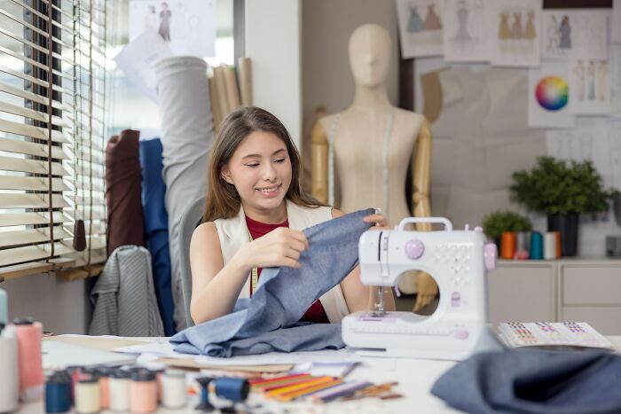 Young woman working on sewing project at home, illustrating how random life decisions can lead to the right place.