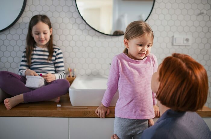 Mother and two young children in a bathroom sharing parenting tips and tricks for everyday family life.